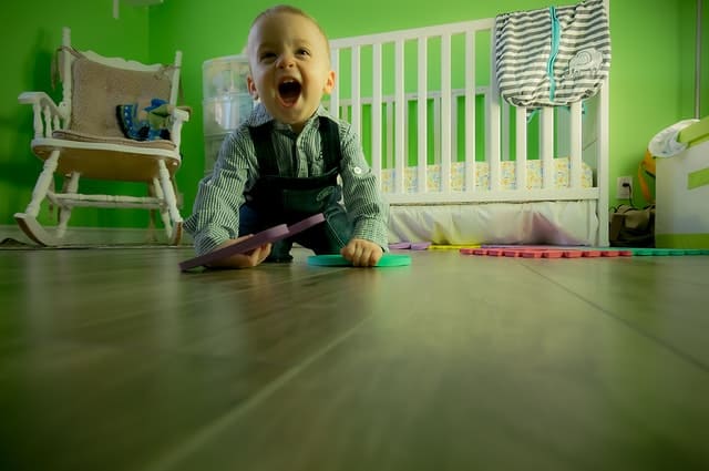 Baby boy smiling while sitting on floor