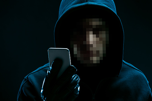 hacker-Portrait of unrecognizable hacker with smartphone