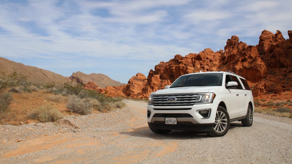 Ford SUV parked outside with canyons in the background.