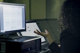 women working on laptop with hands in the air upset