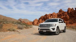 Ford SUV parked outside with canyons in the background.