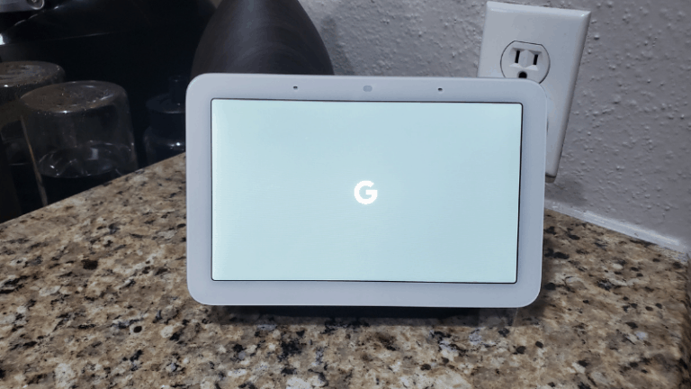 Google nest hub with Google icon sitting on kitchen counter.