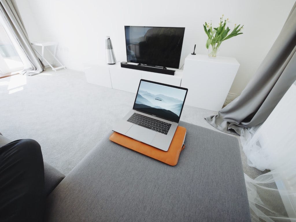 Laptop in front of a TV with a sound bar