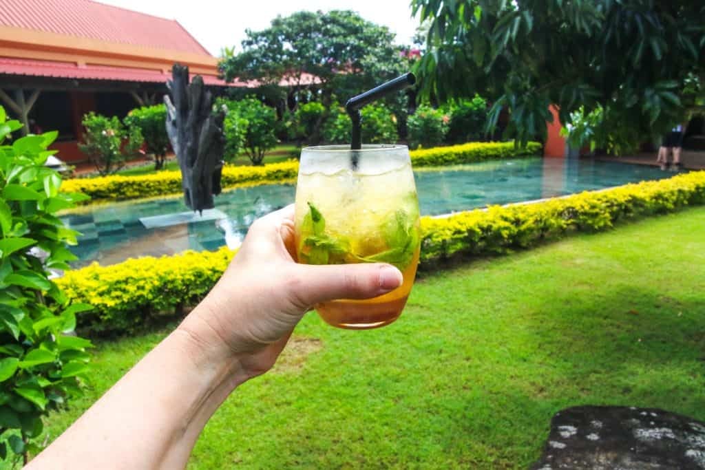 Hand holding drink outside.